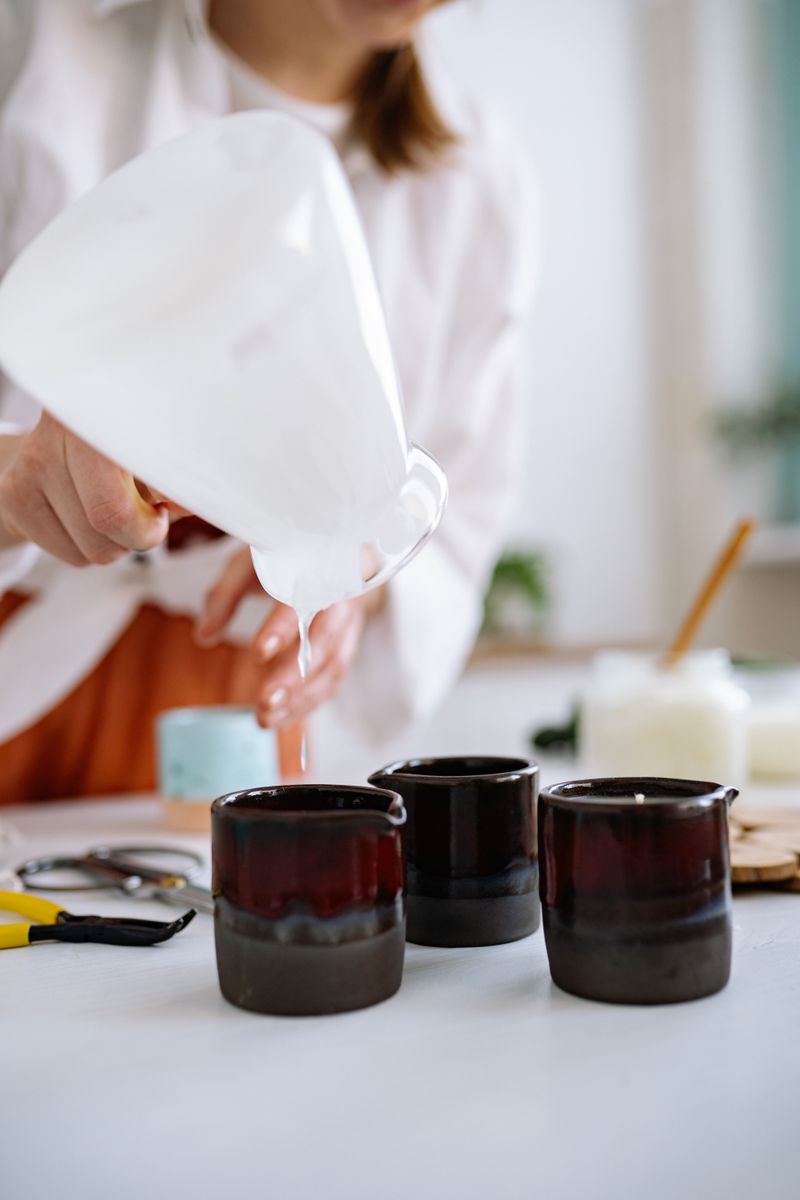 Melted wax being poured into amber jars